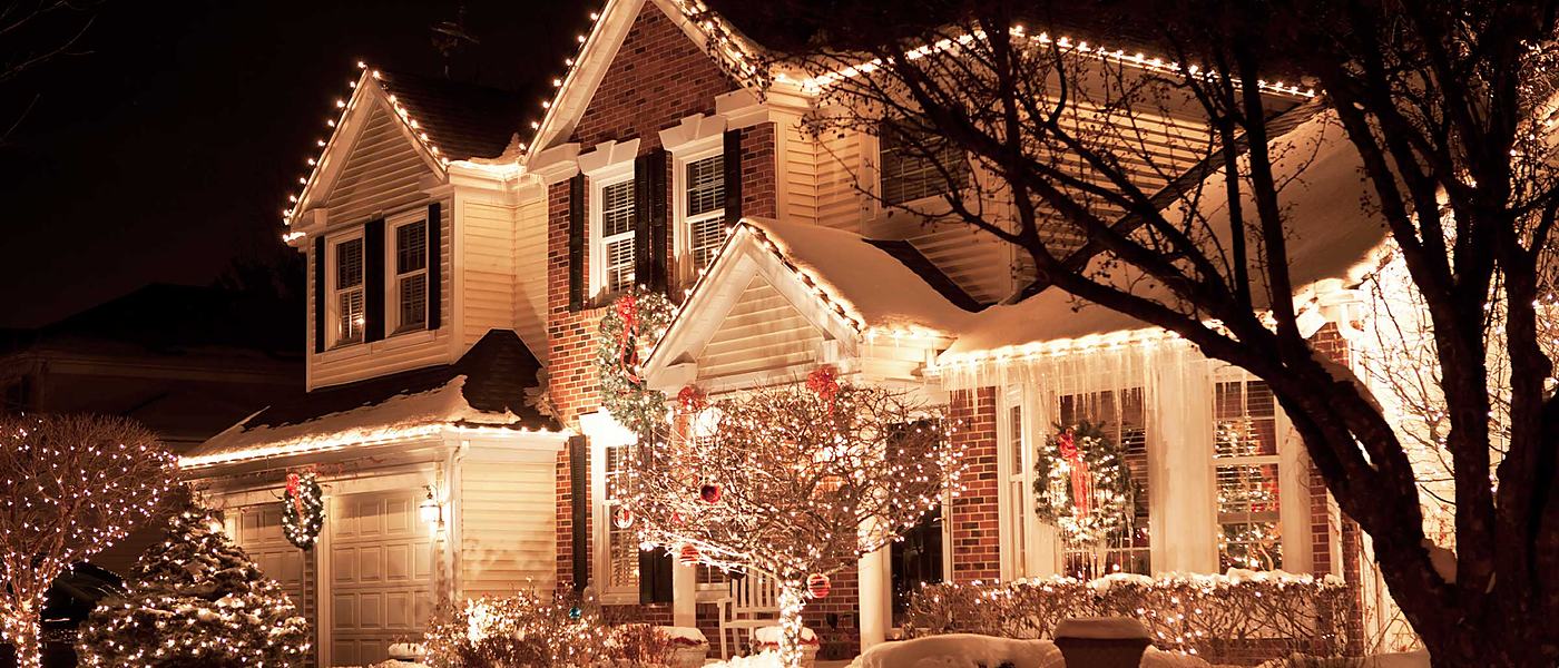 Home with professional holiday lighting on the roofline and trees
