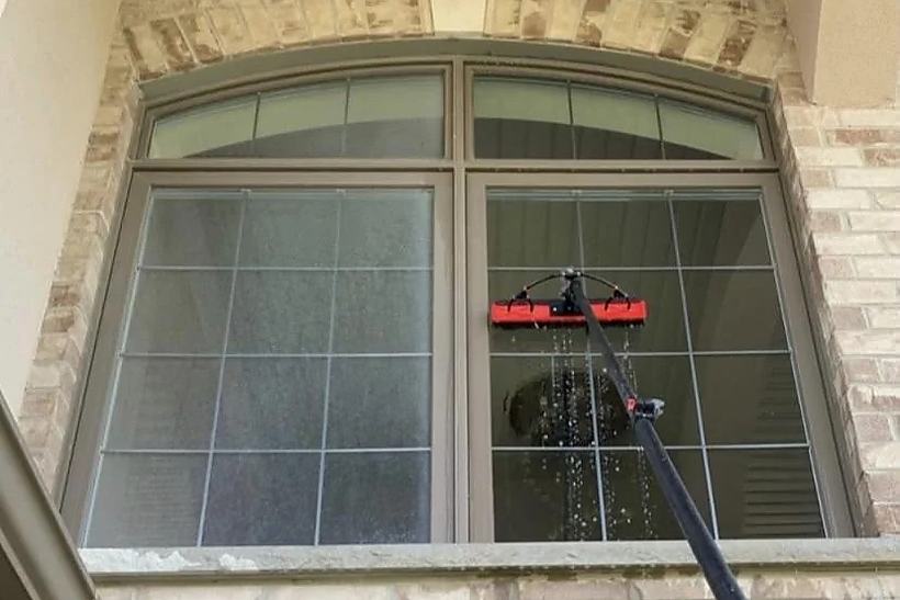 Exterior window being cleaned with a water-fed pole